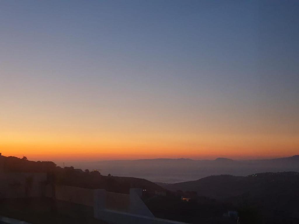 a sunset in the mountains with the sun setting at Villa avec vue panoramique in Tangier