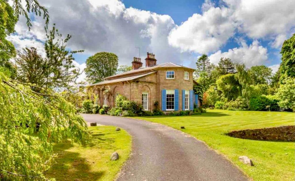 an old stone house with a road in front at Private room & bathroom in Manor House in Maybole