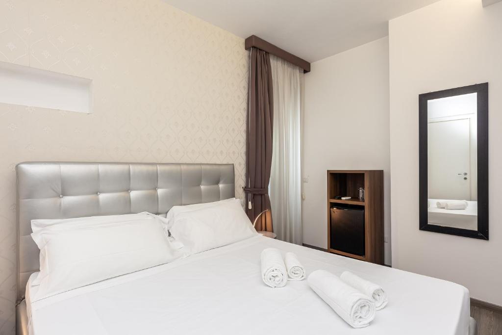 a bedroom with a large white bed with towels on it at Spagna Boutique Suites in Rome