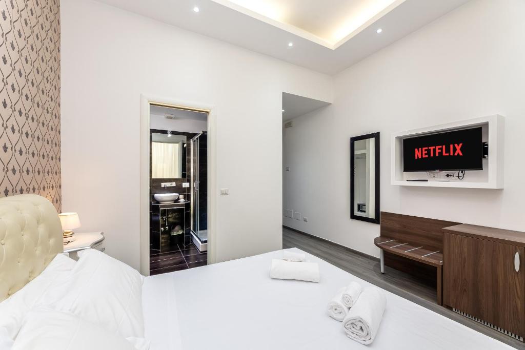a bedroom with a bed and a tv on a wall at Spagna Boutique Suites in Rome