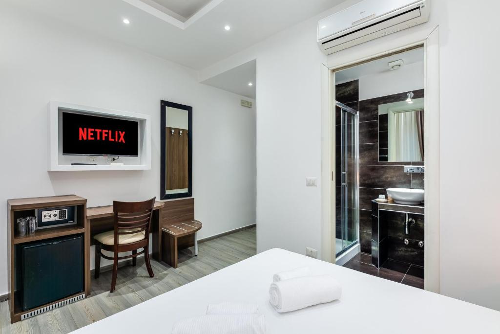 a bedroom with a bed and a tv on the wall at Spagna Boutique Suites in Rome
