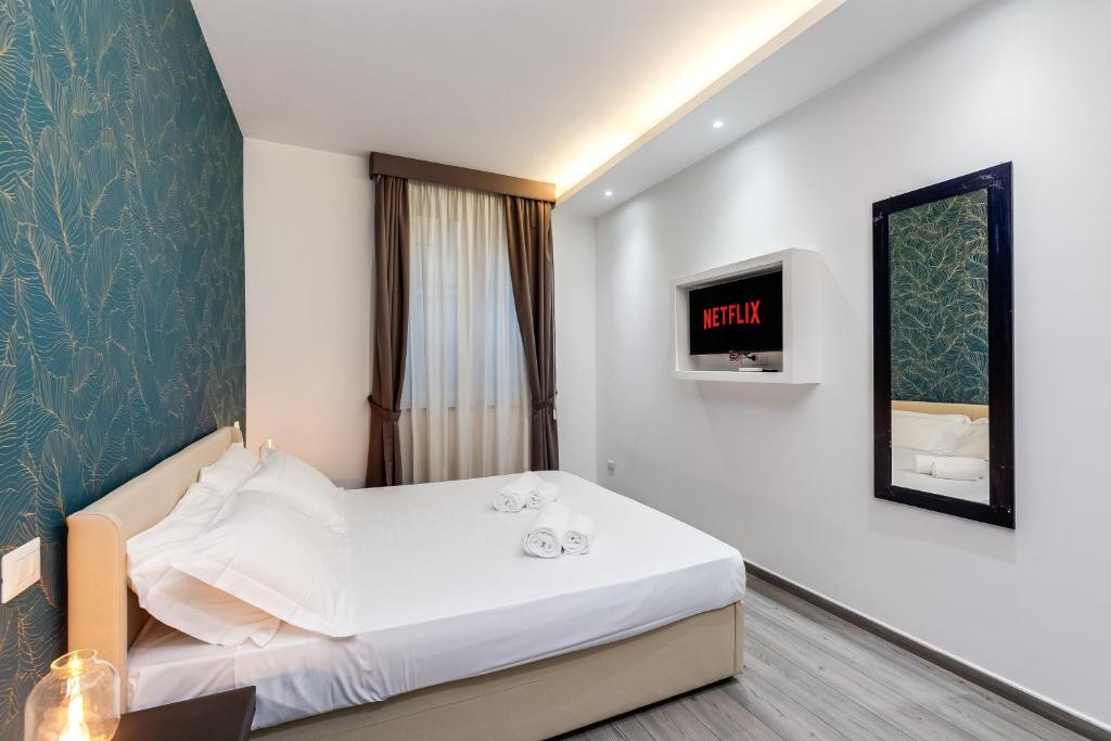 a hotel room with a bed and a tv at Spagna Boutique Suites in Rome