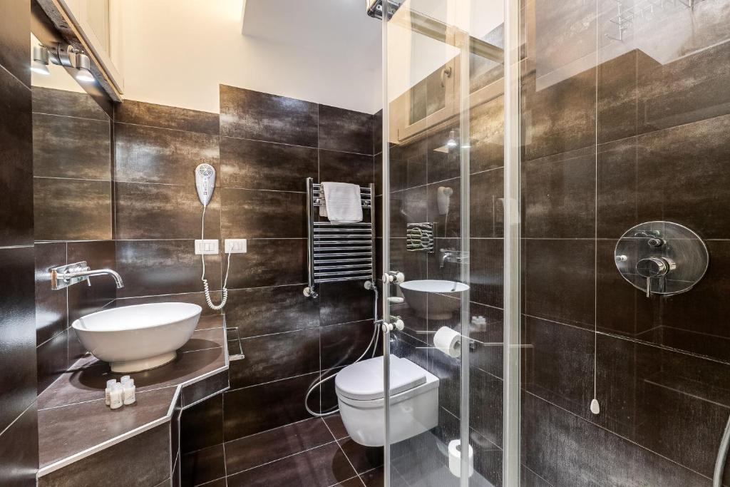a bathroom with a toilet and a glass shower at Spagna Boutique Suites in Rome