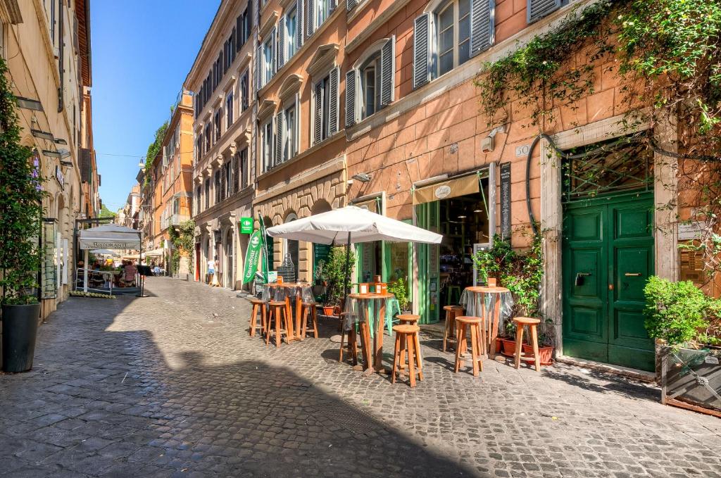 an empty street with tables and chairs and an umbrella at Spagna Boutique Suites in Rome