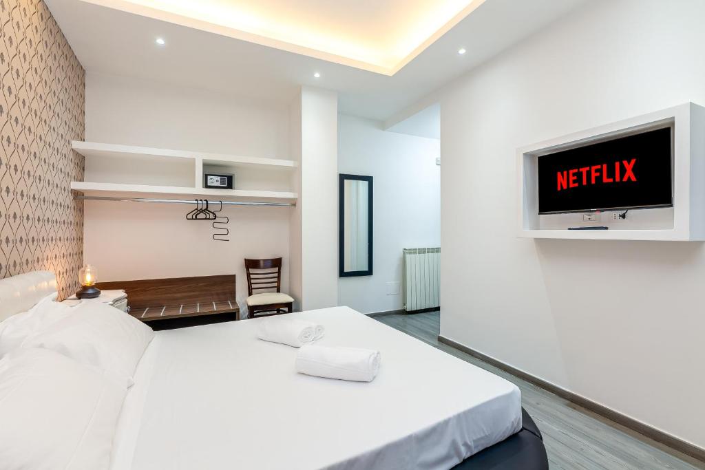 a bedroom with a bed and a tv on a wall at Spagna Boutique Suites in Rome