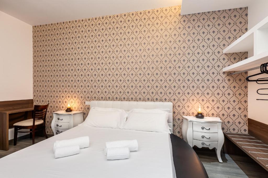 a bedroom with a large white bed and a desk at Spagna Boutique Suites in Rome