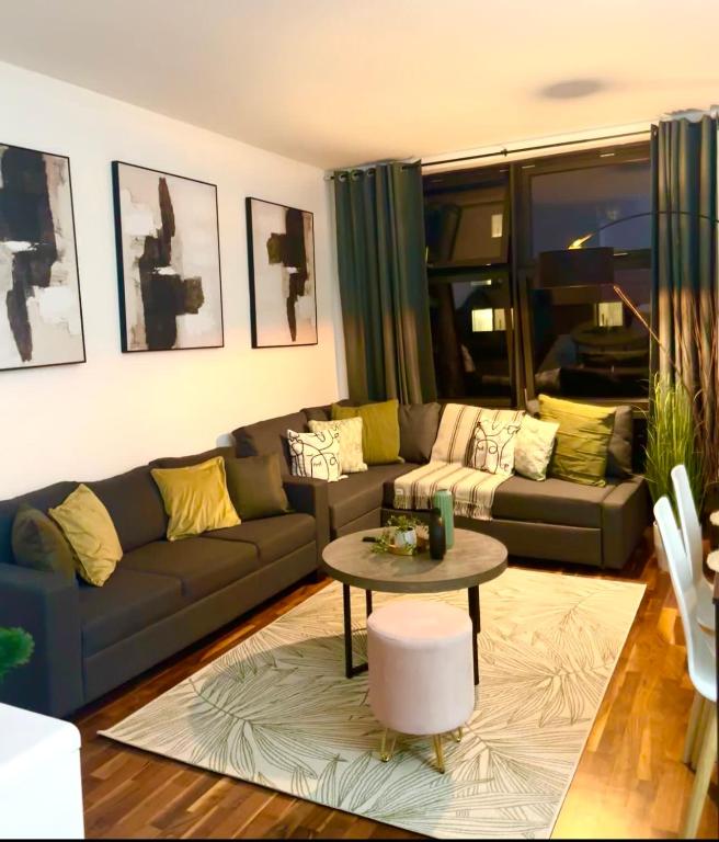 uma sala de estar com um sofá e uma mesa em Spacious One Bed Apartment Near Canary Wharf with SofaBed em Londres