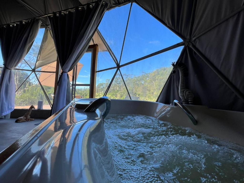 a hot tub in a tent with a view at Refúgio Santa Helena - Domo Safari in Salesópolis