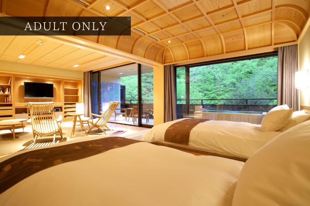 1 dormitorio con 2 camas y ventana grande en Kaichoro, en Shibukawa