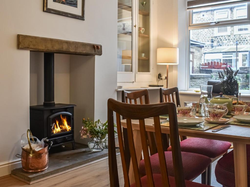 a dining room with a table and a fireplace at Lavender House in Barnoldswick