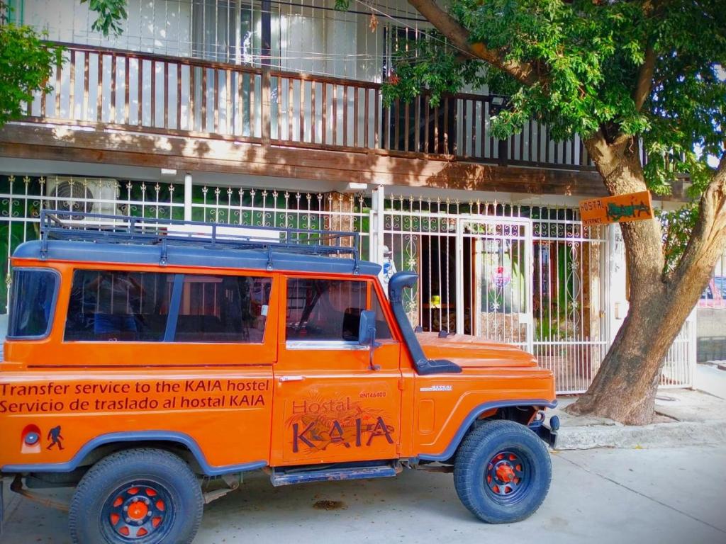 Hostal Kaia في سانتا مارتا: سيارة جيب برتقالية متوقفة أمام مبنى