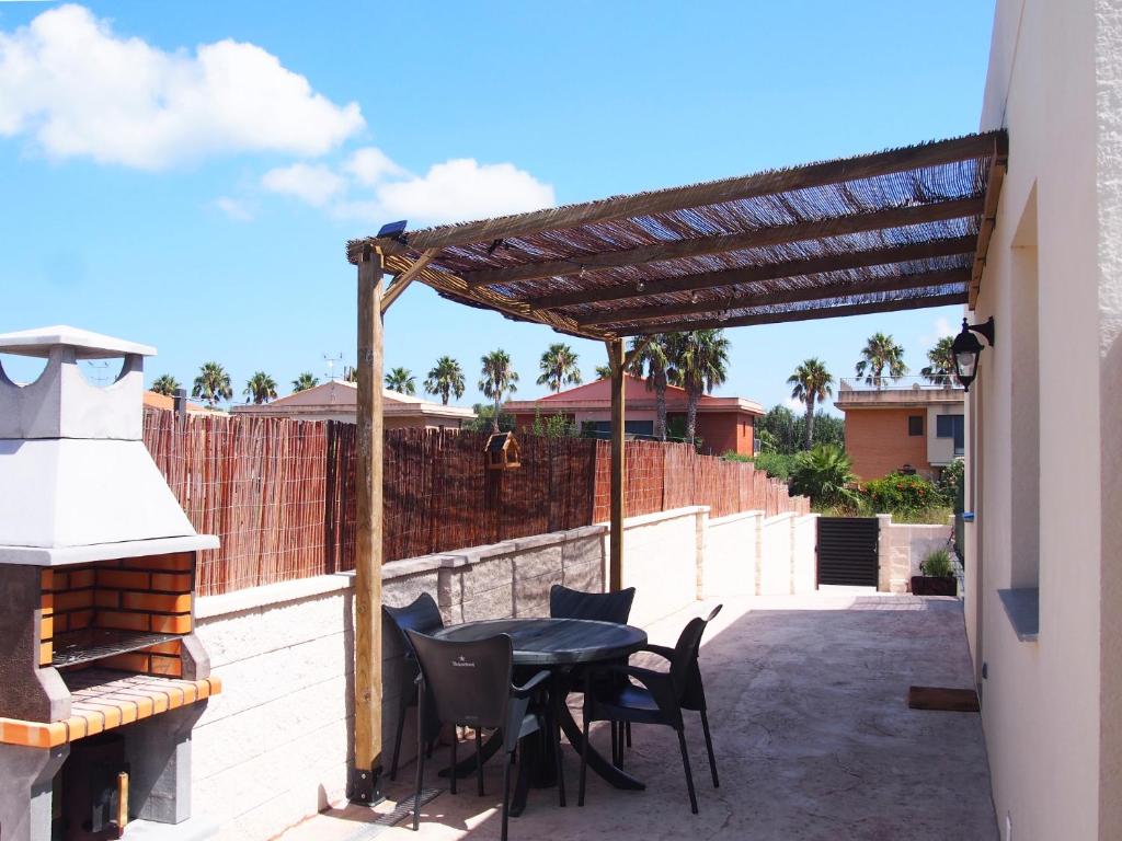 a patio with a table and chairs and a fireplace at Casa en l'Ampolla, patio y bbq, cerca de la playa. in L'Ampolla