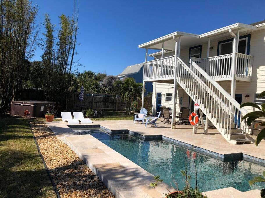 a house with a swimming pool in front of a house at Swansea-by-the-Sea -- Spacious home - heated pool, hot tub, walk to beach! in Ormond Beach