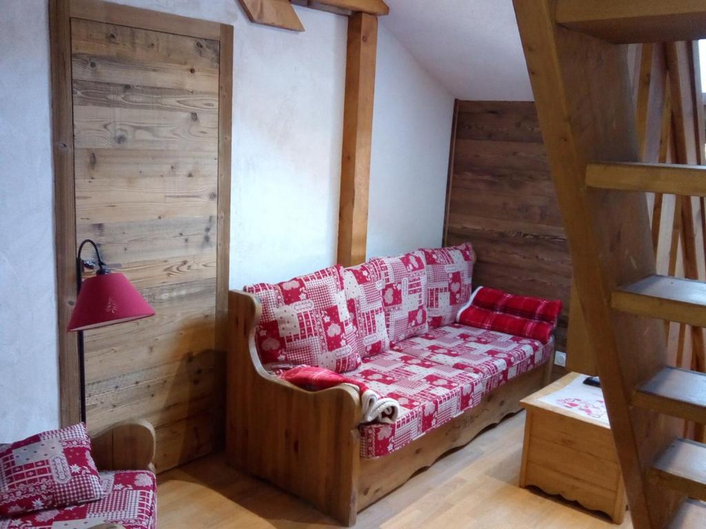 - un salon avec un canapé rouge et des murs en bois dans l'établissement Spacieux duplex cœur Valloire, 12 pers, proche remontées et commerces - FR-1-263-528, à Valloire