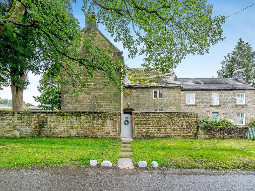 a brick house with a door with the number on it at Manor House Cottage in Highpeak Junction