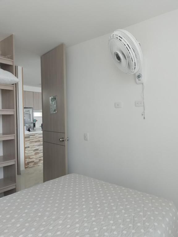 Habitación blanca con 1 cama con ventilador en Acogedor Apartamento en Ricaurte con BBQ, en Girardot