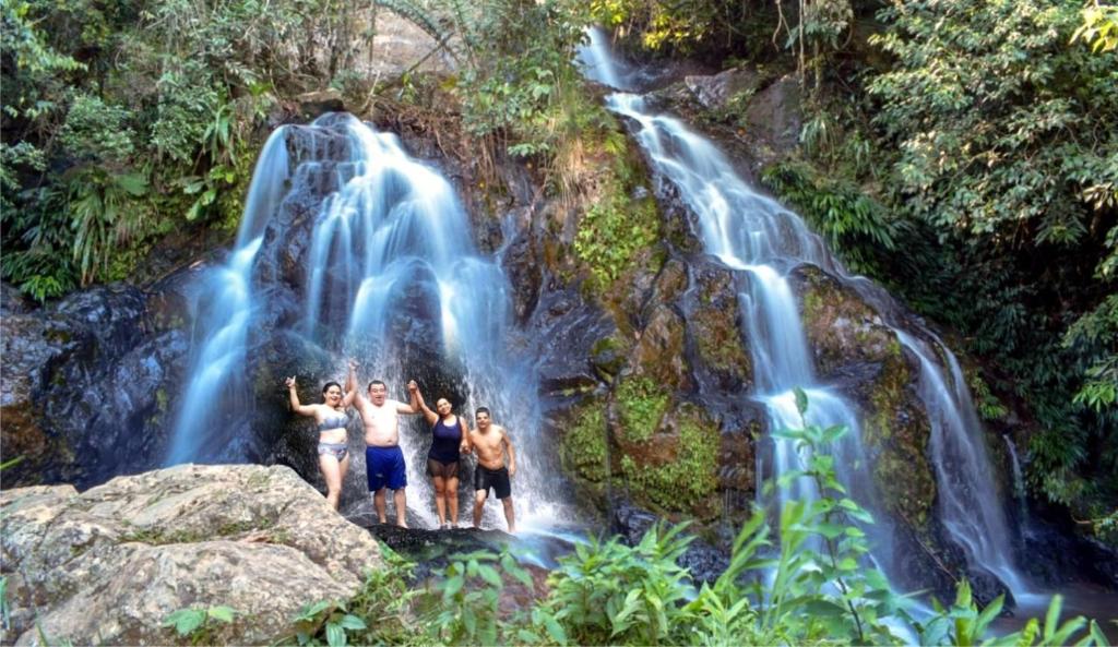 un groupe de personnes debout devant une cascade dans l'établissement Reserva Natural Cascadas de Padilla, à Lérida