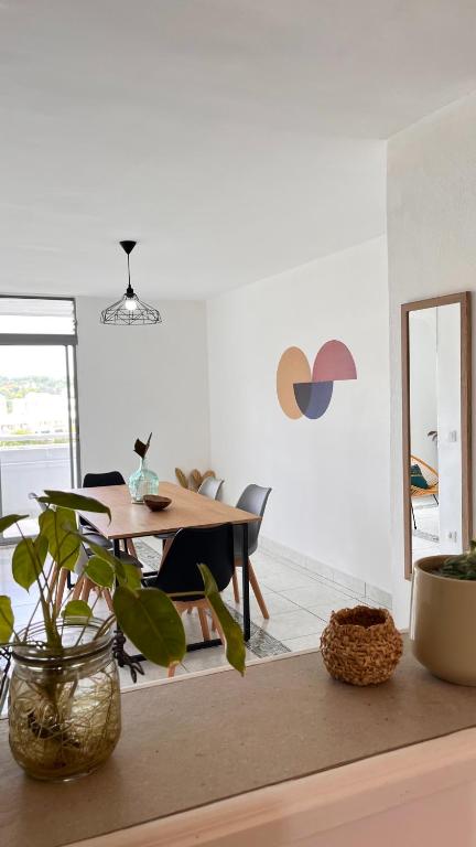 a dining room with a table and a mirror at L'Escale, appt partagé, shared apartment in Pointe-à-Pitre