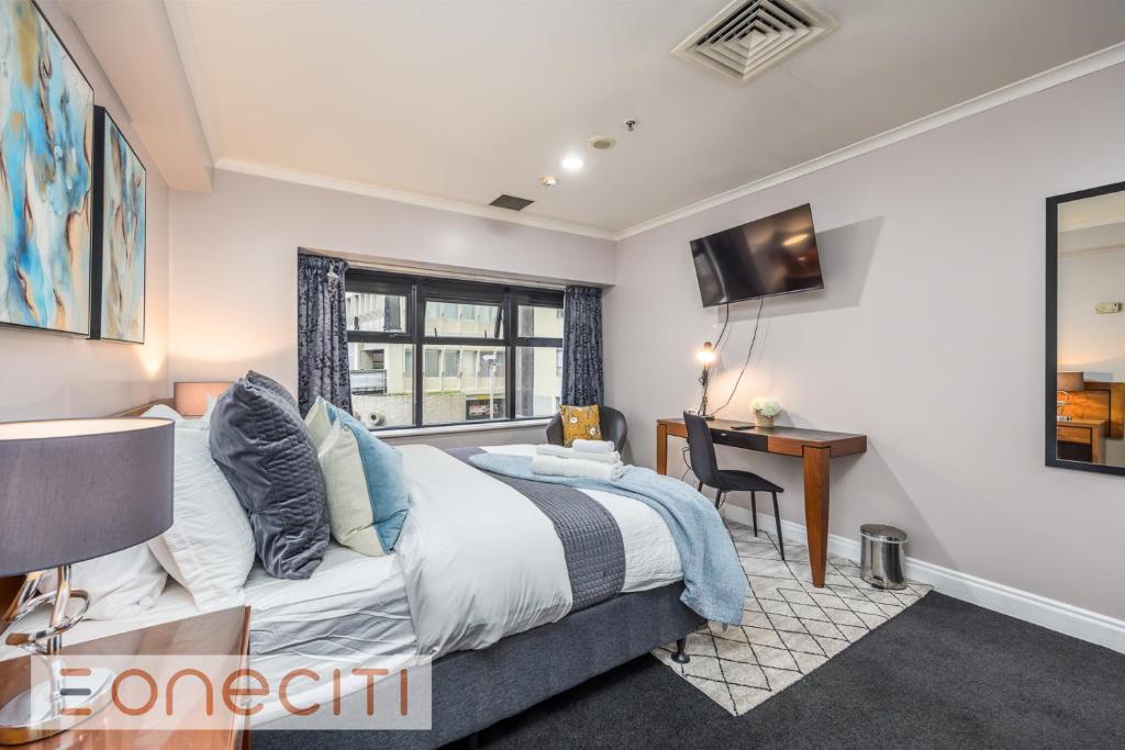 1 dormitorio con cama, escritorio y ventana en Hidden gems studio apartment en Auckland