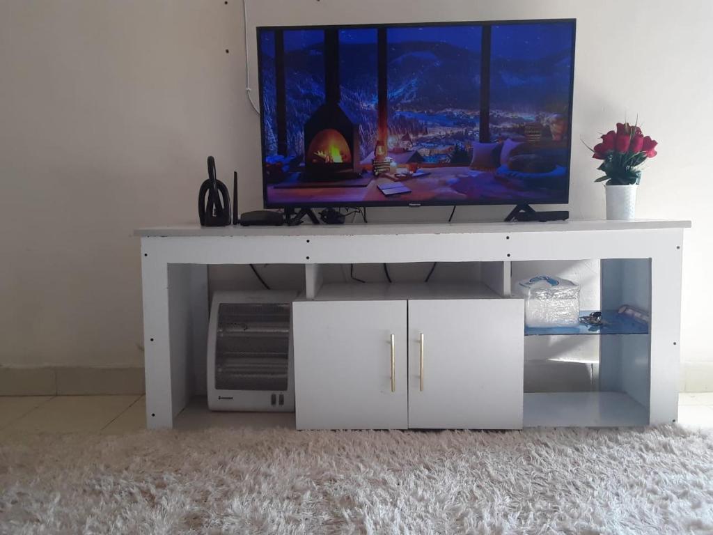 a white entertainment center with a tv on top at Fid's Place in Nyahururu