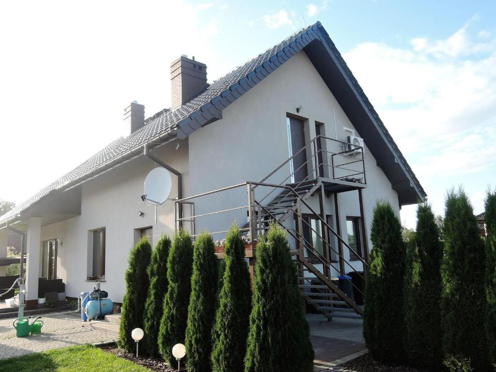 ein weißes Haus mit einer Wendeltreppe davor in der Unterkunft Apartment with a swimming pool in Stepniczka in Stepnica
