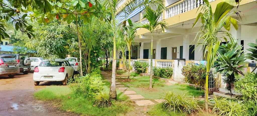 a car parked in front of a building with palm trees at Durga Beach Resort in Parxem