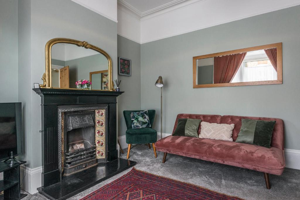 - un salon avec un canapé rouge et une cheminée dans l'établissement Picton House: Charming 3 bed property in quiet location, à Ramsgate