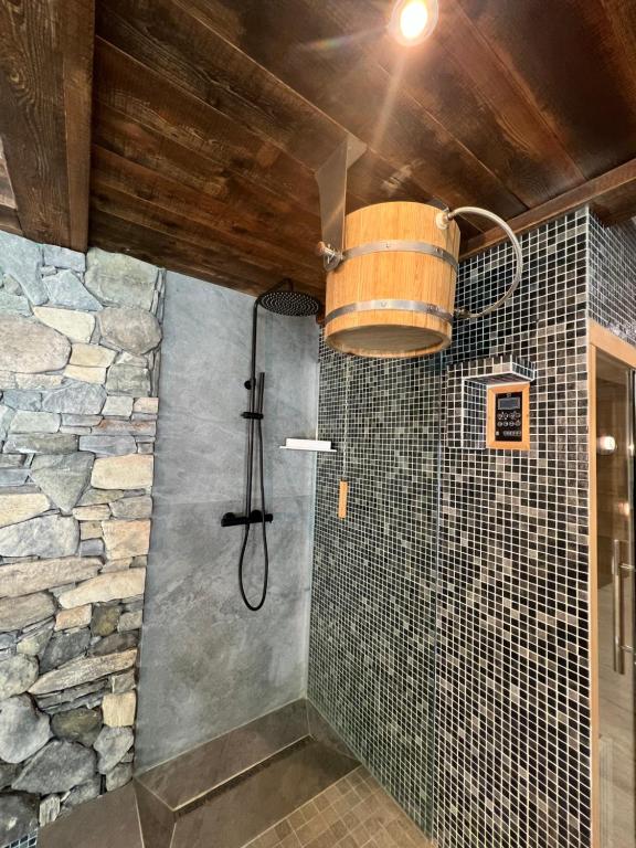 a bathroom with a shower with a bucket on the wall at Châlets AOKI in Valloire