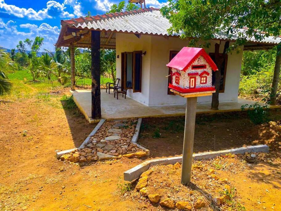 uma pequena casa com uma casa de pássaros num poste em Nelumgala Cottage -Village Experience em Galewela