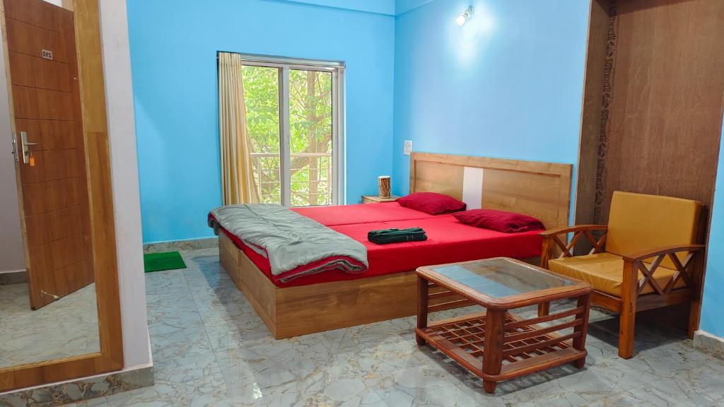 a blue bedroom with a bed and a chair at AYM Yoga Resort Arambol GOA in Arambol