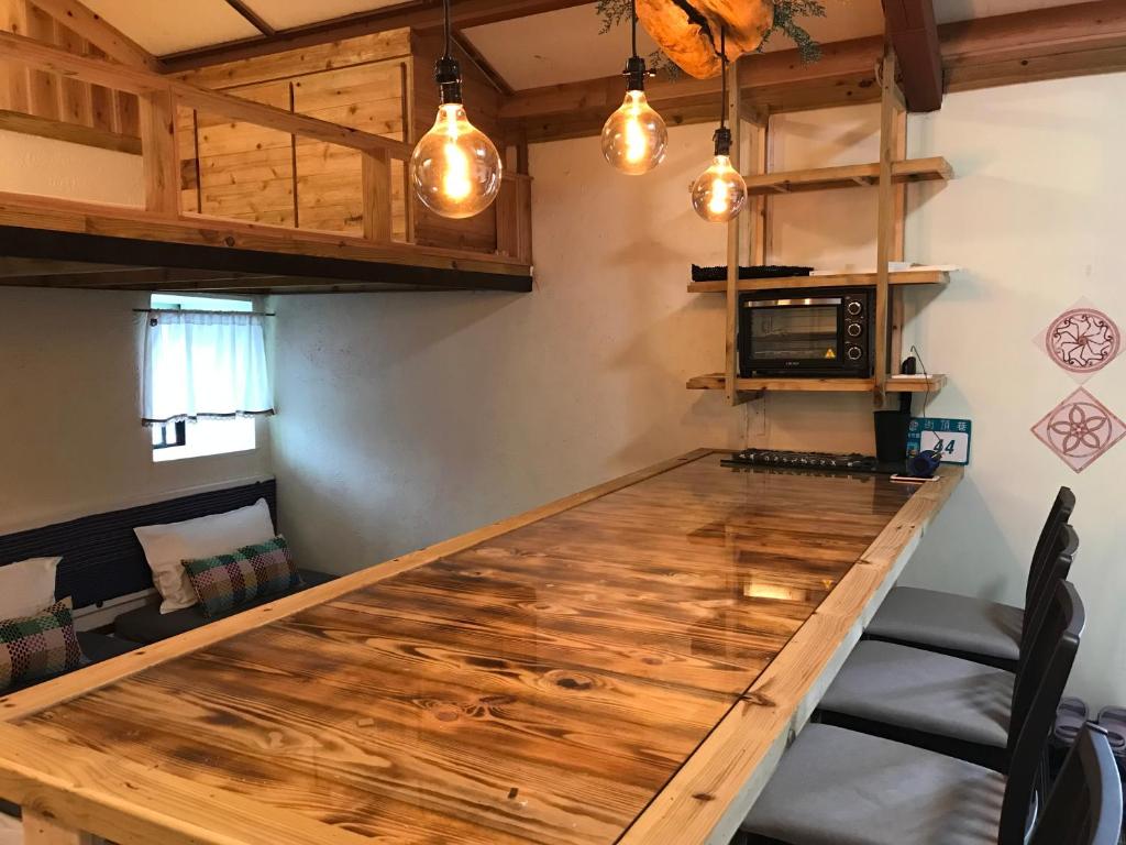 a large wooden table in a kitchen with lights at A-HOME in Jiufen