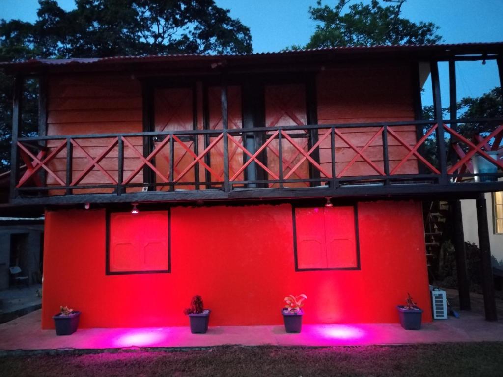 una casa roja con luces rosas delante en Finca Agroturistica Villaverde, en Nuevo Chagres