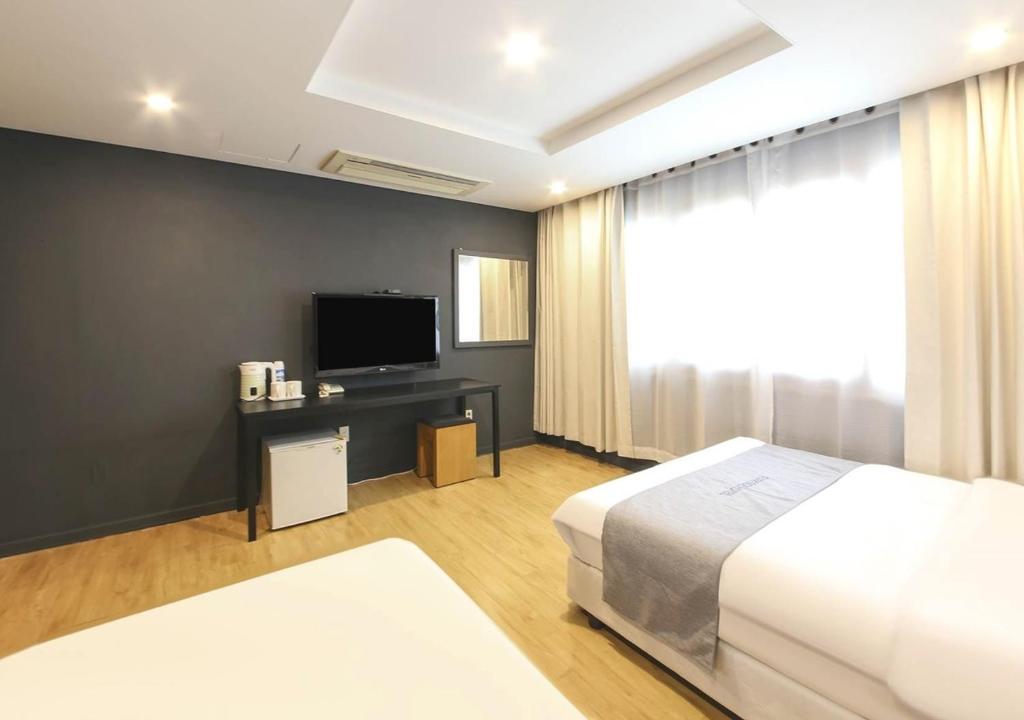 Postel nebo postele na pokoji v ubytování Jeju Parkside Tourist Hotel