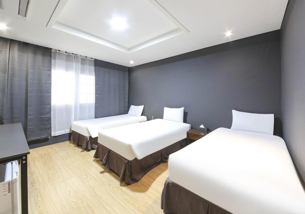 Postel nebo postele na pokoji v ubytování Jeju Parkside Tourist Hotel