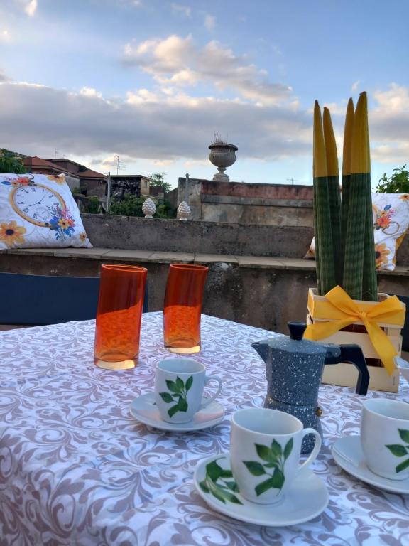 een tafel met kopjes en schotels op de top bij Casa Vacanze EtnaMolù in Giarre