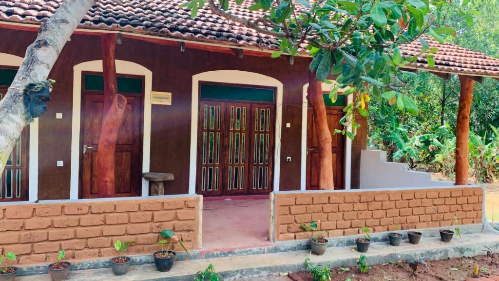 uma casa com portas vermelhas e uma parede de tijolos em Sigiriya Chena Villa em Sigiriya