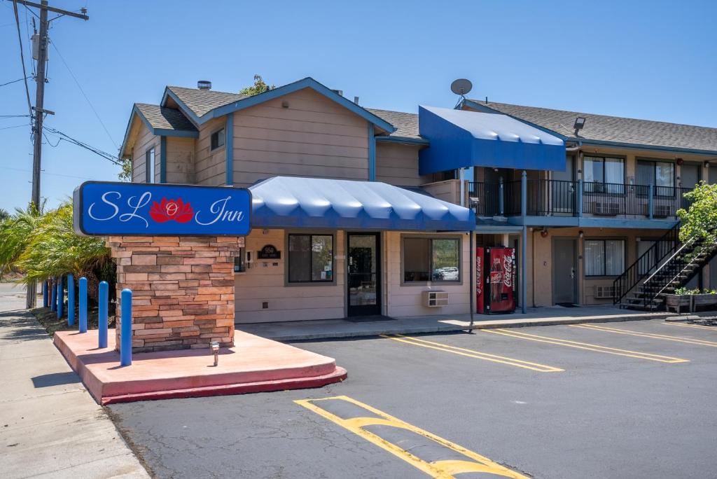 un negozio con un cartello blu in un parcheggio di DOWNTOWN SLO INN - SAN LUIS OBISPO a San Luis Obispo