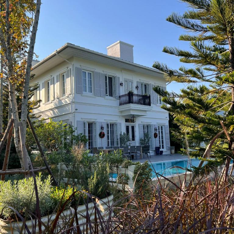 a white house with a pool in front of it at La Campagne Villa Chiangmai in Chiang Mai