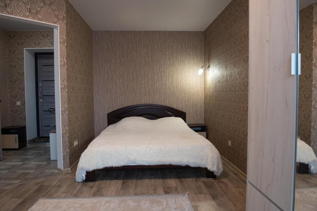 Un dormitorio con una cama con una manta blanca. en Академіка Корольова 20 1, en Cherkasy