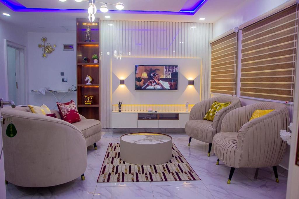 a living room with two couches and a tv at Thistle Greens Apartment in Ikeja