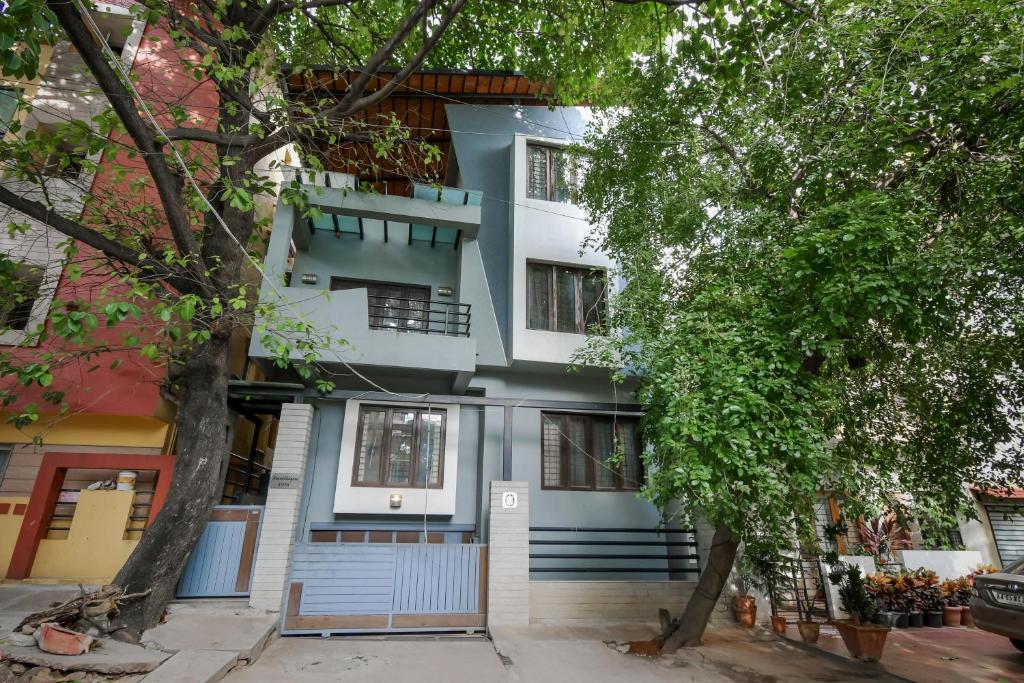 une maison bleue avec des arbres devant elle dans l'établissement HomeSlice Manor, à Bangalore