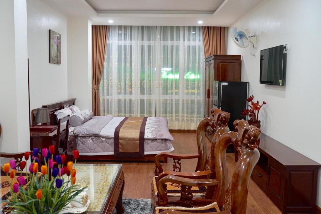 Sala de estar con cama y mesa en Khách Sạn Sông Hiến en Cao Bằng