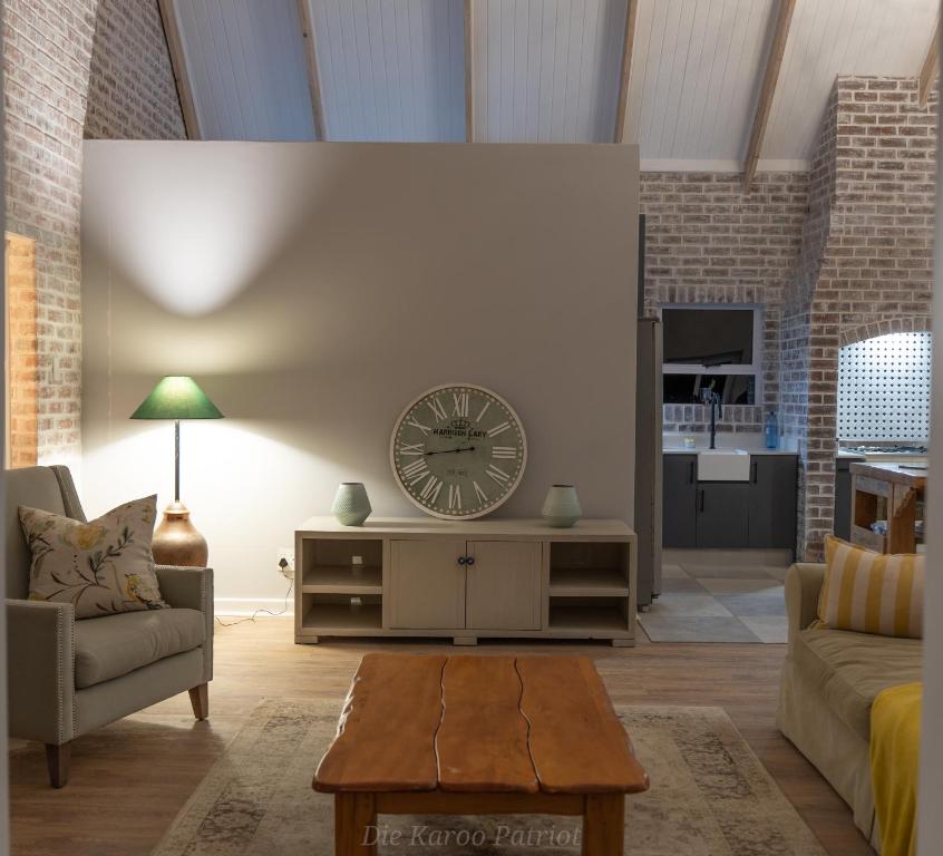 a living room with a large clock on the wall at Die Karoo Patriot in Orania