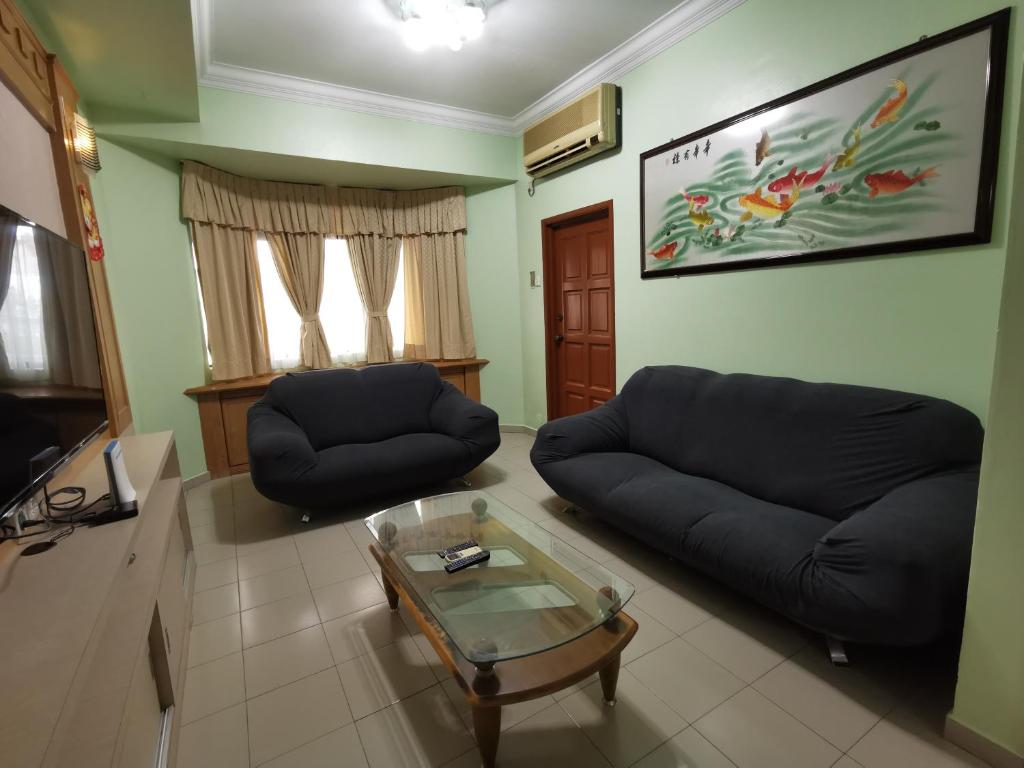 Sala de estar con 2 sofás y mesa de centro en DIY Palm Court 3BR Apartment, 7 Guests en Kuantan
