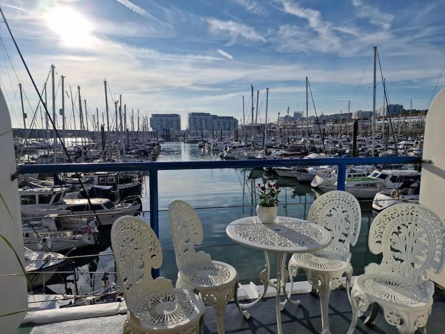 een tafel en stoelen op een balkon met een jachthaven bij Sea Breeze in Brighton Marina with Free Parking in Brighton & Hove