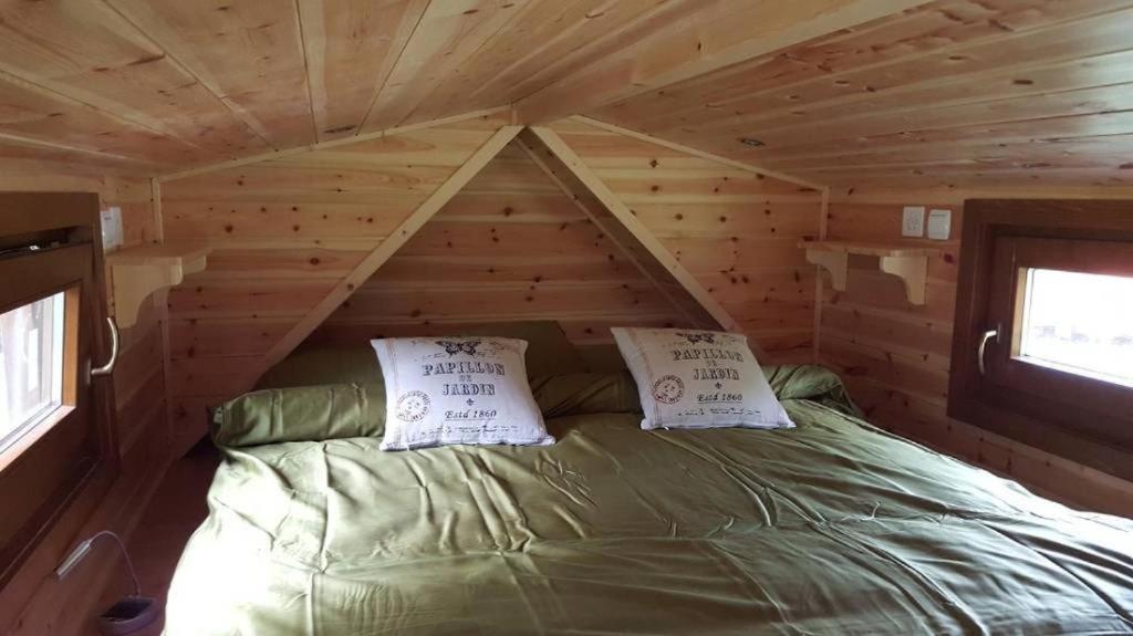 1 cama en una cabaña de madera con 2 almohadas en Tiny House Waldschmied 1, 
