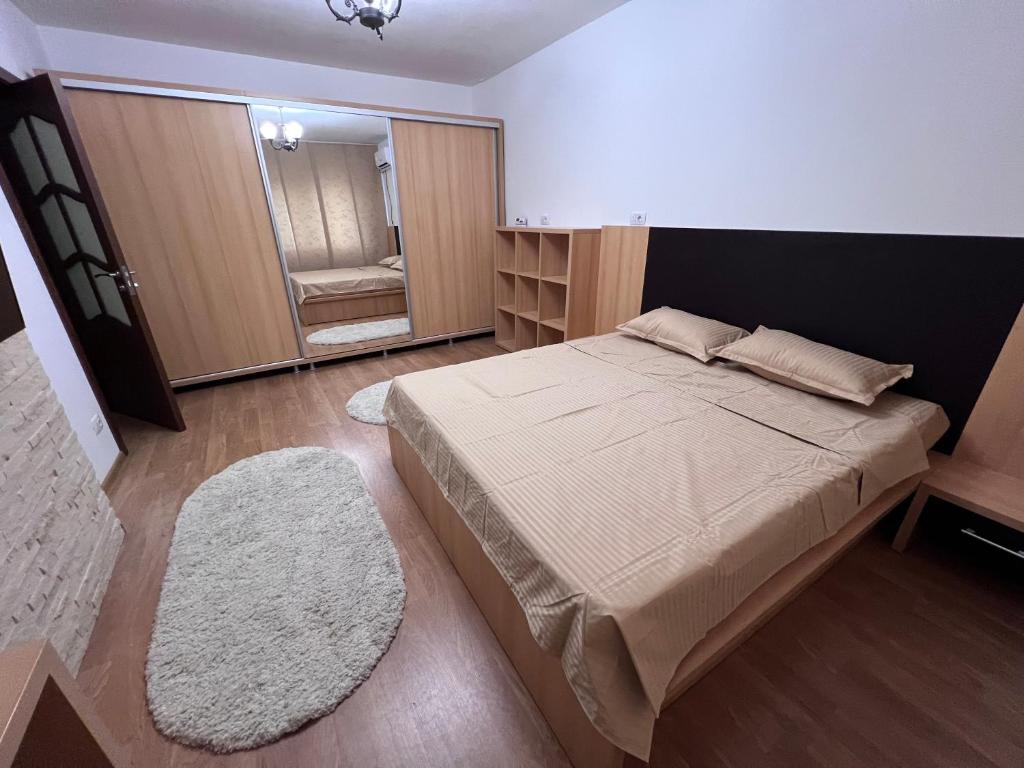 ein Schlafzimmer mit einem großen Bett und einem Spiegel in der Unterkunft MNM Mitropolie in Iaşi