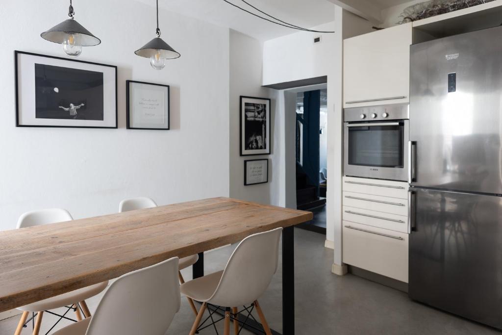 a kitchen with a wooden table and a refrigerator at Esclusiva Casa indipendente in Centro in Udine