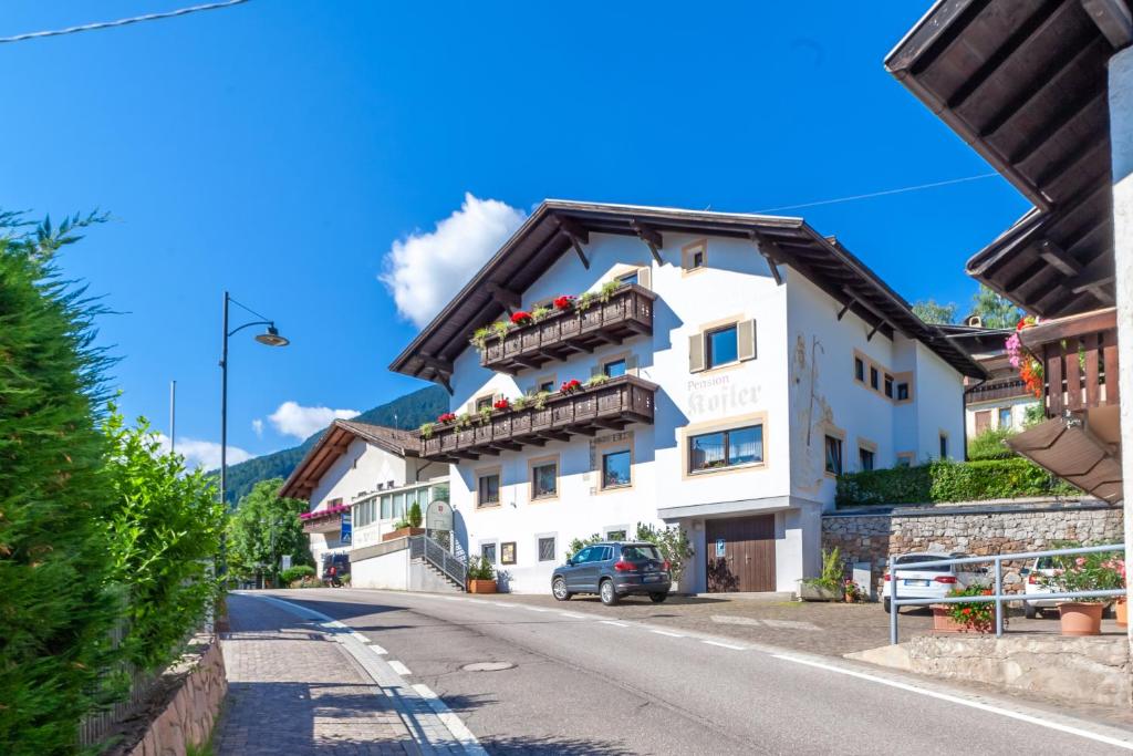 a white building on the side of a road at Pension Kofler in Vollan