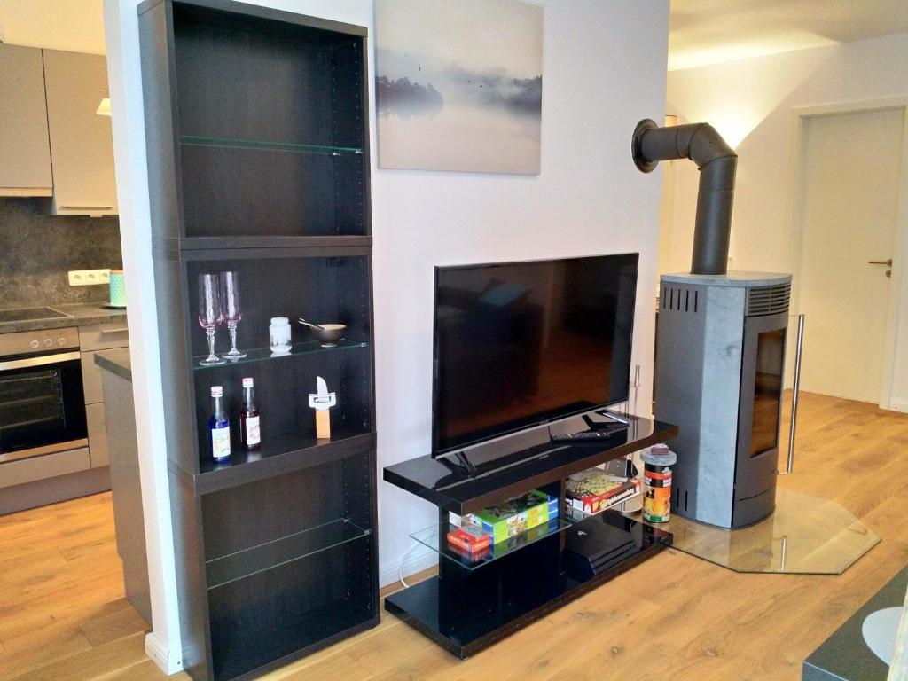 a living room with a television and a fireplace at Ferienwohnung im Mittelpunkt in Nortorf